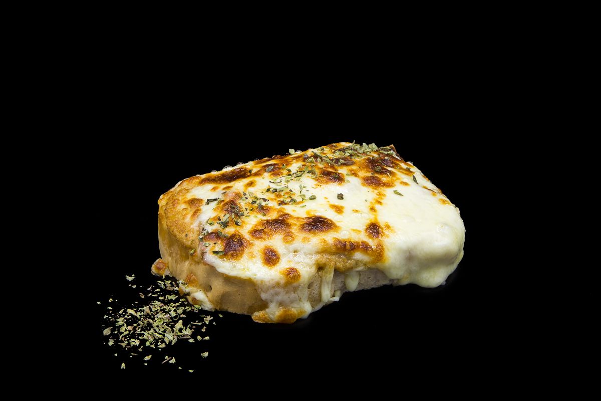 Gratinato tostato con salsa al formaggio, fette di porro e pancetta