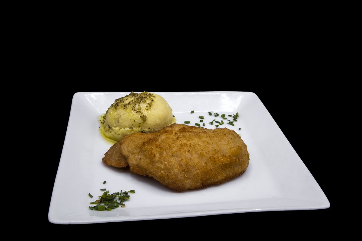 Breaded pork loin with mashed potatoes seasoned with garlic