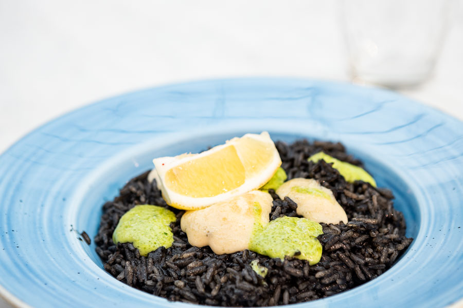Risotto-style rice with baby squid cooked in ink and garlic mayonnaise