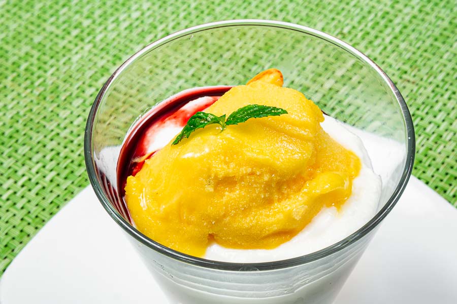 Bicchiere freddo di panna cotta e gelato al mango