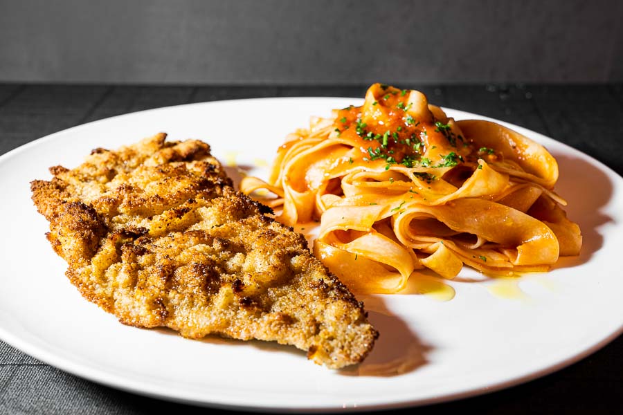 Breadcrumbed veal escalope served with pasta