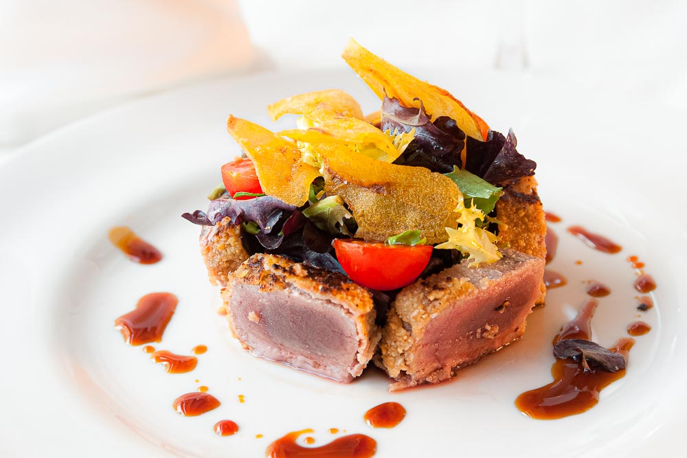 Tuna with almond crust, green leaves, plantain and soy vinaigrette