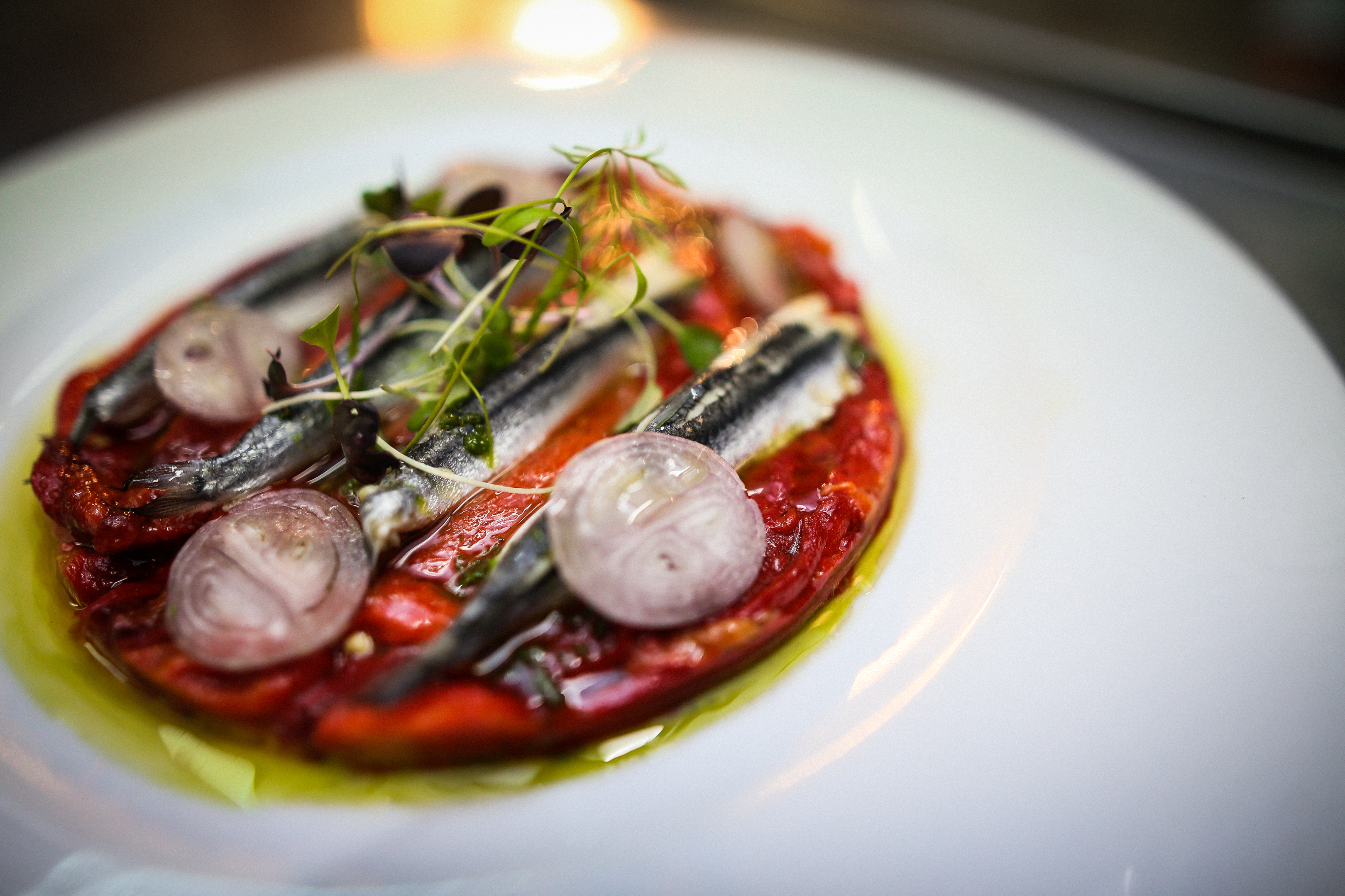 Marinated anchovies on roasted peppers and parsley oil