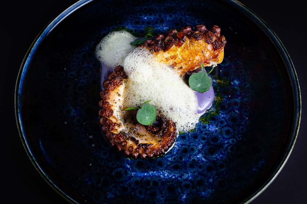 Grilled octopus on creamy violet potato parmentier and passion fruit air