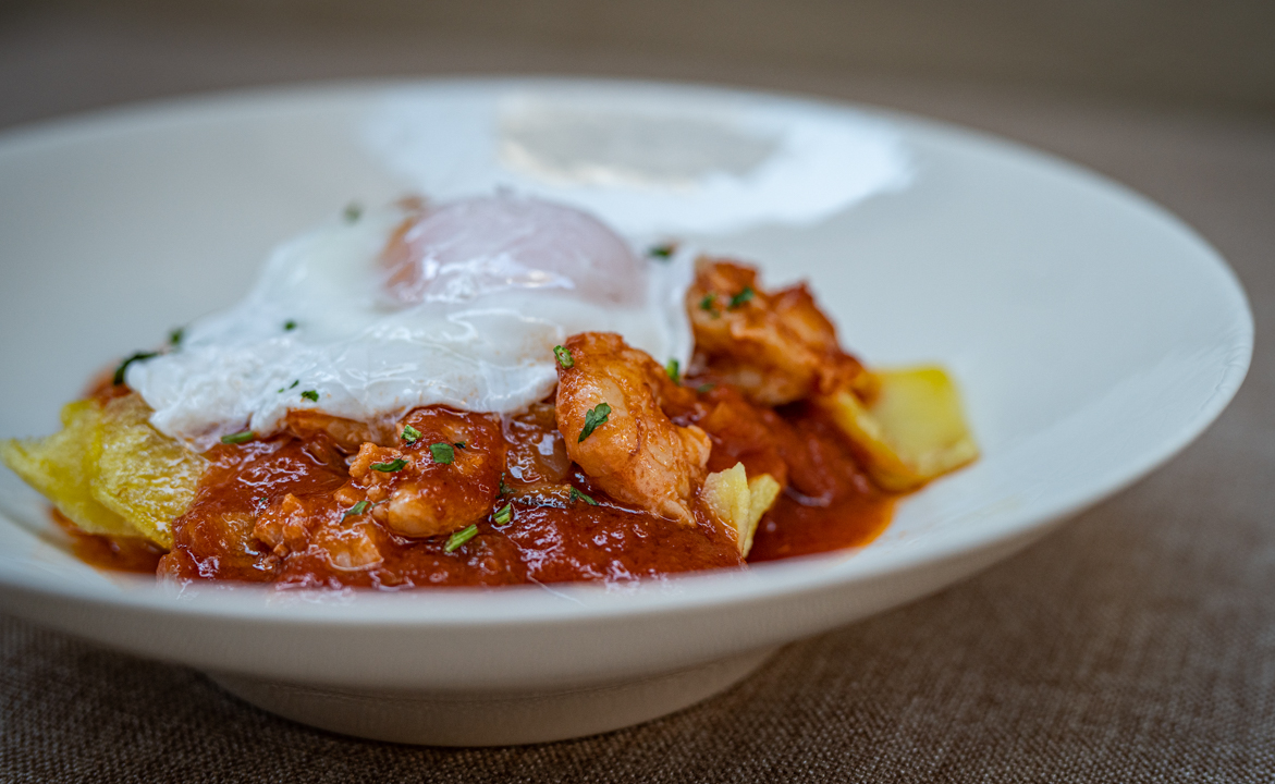 Tomato with prawns, poached egg and fried potatoes