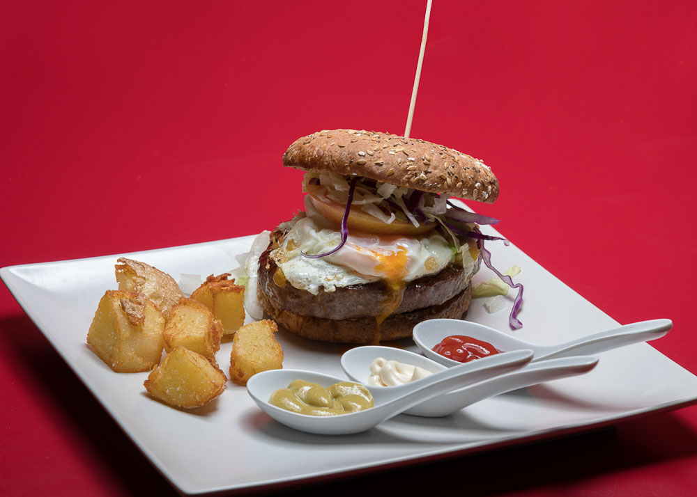Beef burger with bacon, cheddar, fried onion, pickle, lettuce, tomato, egg and potato