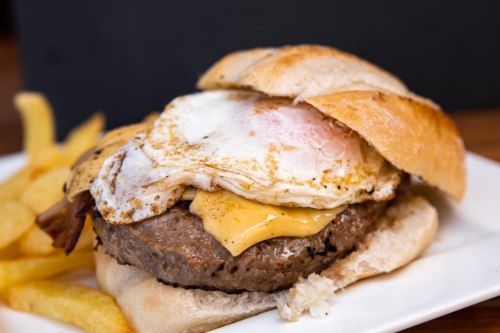 Ochsenfleisch-Burger mit Cheddar, Ei, Bacon und Pommes Frites